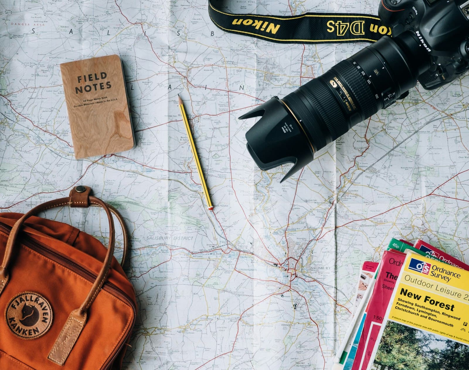 Travel journal and camera on a wooden surface suggesting trip planning